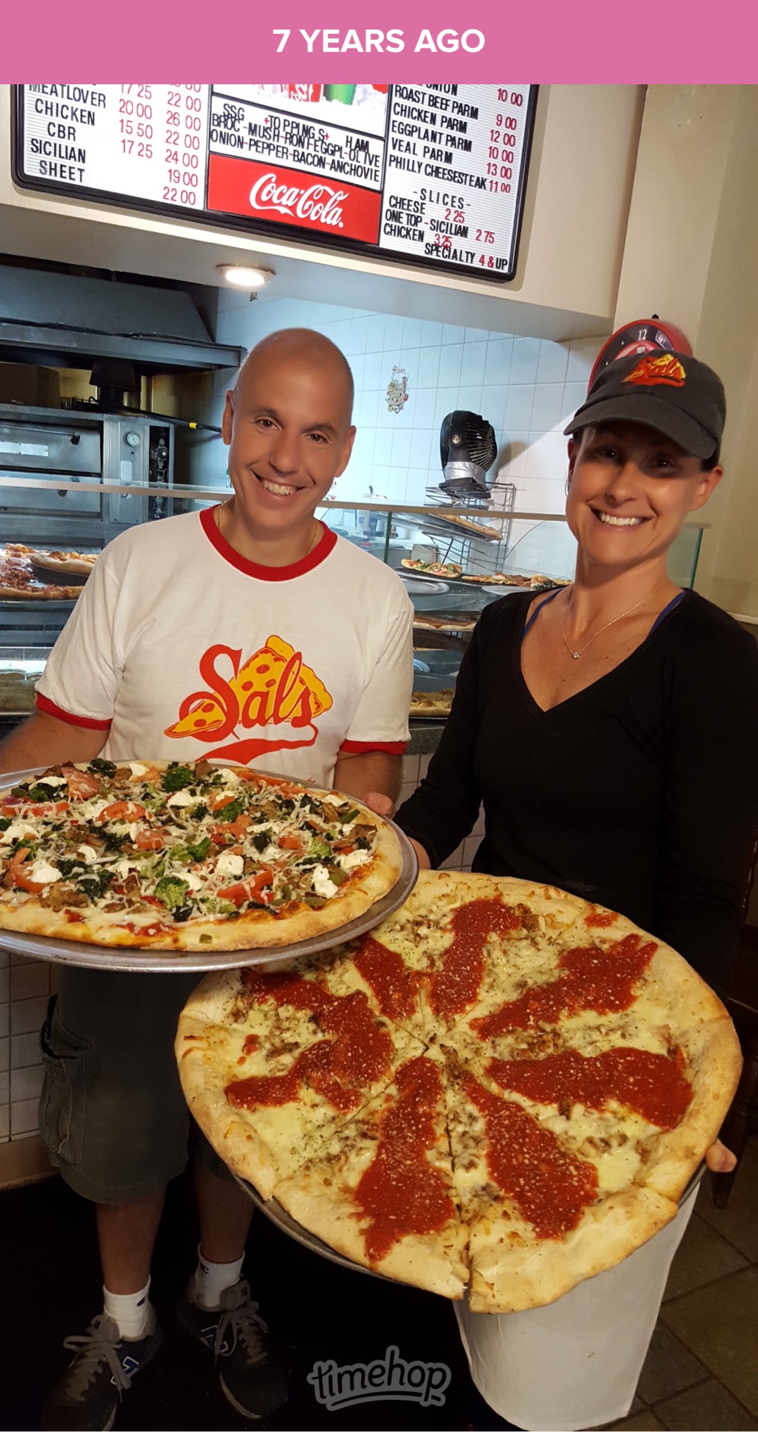 Johnny and Jen, the heart of Sal's Pizzeria, holding fresh pizzas